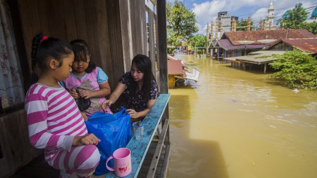 Warga bertahan di rumahnya saat banjir merendam permukiman di Jalan Biduri, Kecamatan Satui, Kabupaten Tanah Bumbu, Kalimantan Selatan, Sabtu (15/5/2021). [ANTARA FOTO/Bayu Pratama S]