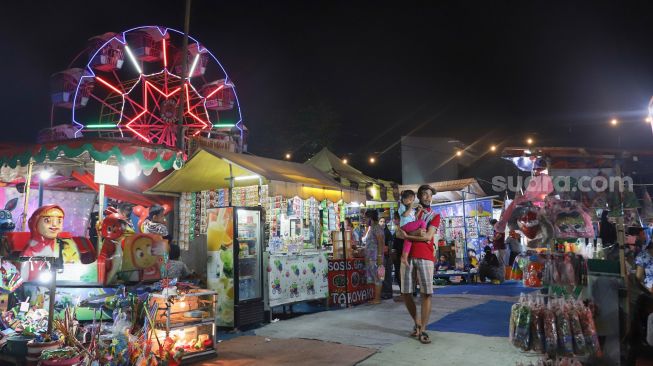 Suasana di pasar malam BKT (Banjir Kanal Timur) di kawasan Duren Sawit, Jakarta Timur, Sabtu (15/05/2021). [Suara.com/Alfian Winanto]
