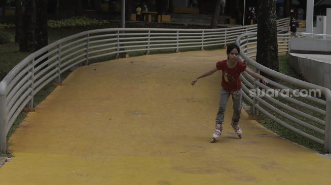 Seorang anak bermain sepatu roda di Taman Puring, Kebayoran Baru, Jakarta, Minggu (16/5/2021). [Suara.com/Angga Budhiyanto]
