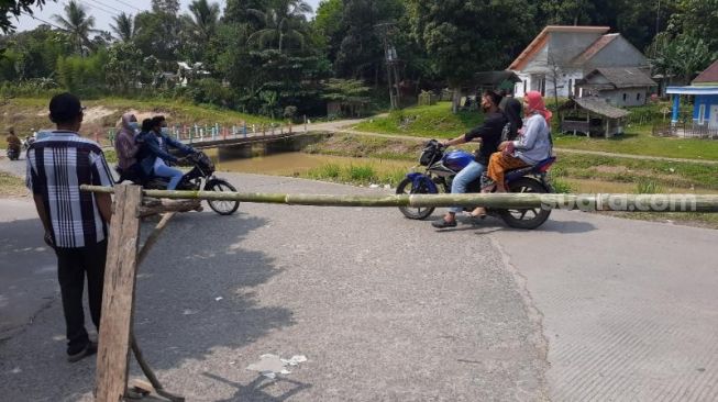 Pengunjung putar balik setelah akses masuk ke Makam Keramat Solear, Kabupaten Tangerang, ditutup karena pengunjung membeludak, Senin (17/5/2021). [Suara.com/Wivy Hikmatullah]