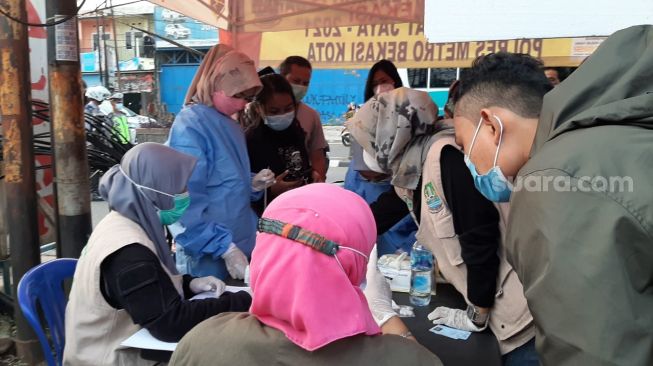 Petugas melakukan pemeriksaan rapid test antigen terhadap pemudik di Posko Bekasi Timur, Senin (17/5/2021) [Suara.com/Ummi Hadyah Saleh]