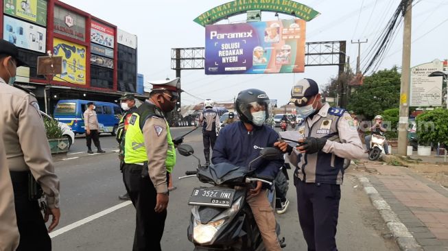 Petugas melakukan pemeriksaan tes rapid antigen terhadap pemudik di Posko Bekasi Timur, Senin (17/5/2021). [Suara.com/Ummi Hadyah Saleh]
