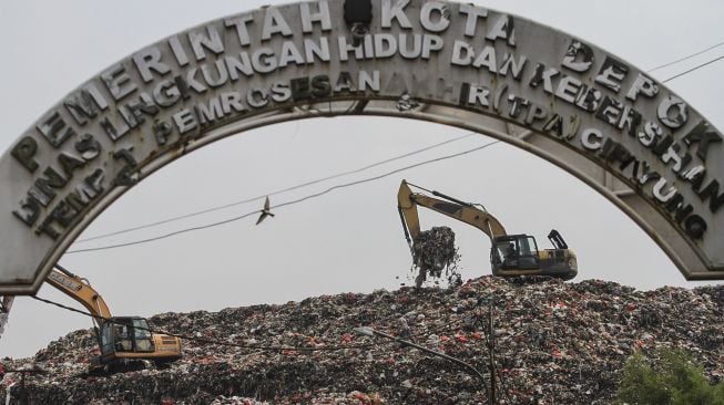 Alat berat mengeruk sampah di TPA Cipayung, Depok, Jawa Barat, Senin (17/5/2021). ANTARA FOTO/Asprilla Dwi Adha