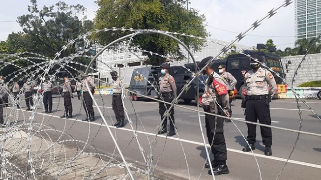 Polisi berjaga di depan kantor Kedutaan Besar Amerika Serikat untuk Republik Indonesia, DKI Jakarta, Selasa (18/5/2021). Kantor Kedubes AS jadi sasaran demonstran pro-Palestina. [Suara.com/Yosea Arga Pramudita]