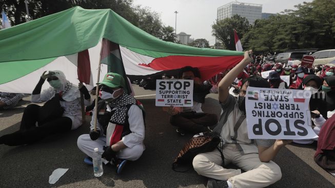 Massa aksi membawa poster saat mengikuti aksi solidaritas dukung Palestina terkait kekerasan yang terjadi beberapa waktu lalu oleh Israel di depan Kedubes AS, Jakarta, Selasa (18/5/2021). [Suara.com/Angga Budhiyanto]