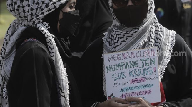 Massa aksi membawa poster saat mengikuti aksi solidaritas dukung Palestina terkait kekerasan yang terjadi beberapa waktu lalu oleh Israel di depan Kedubes AS, Jakarta, Selasa (18/5/2021). [Suara.com/Angga Budhiyanto]