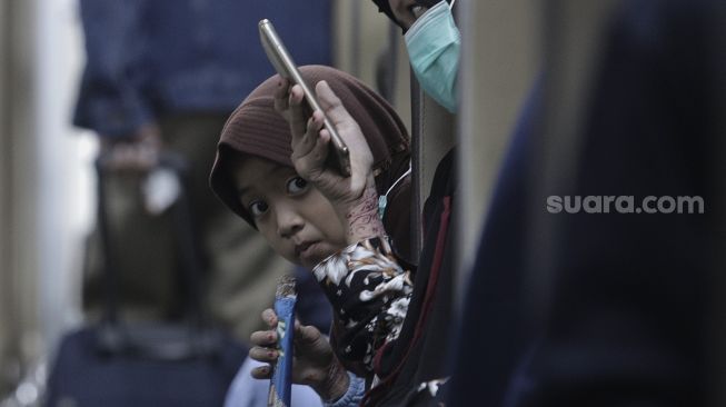 Peumpang berada di dalam kereta api yang berhenti di Stasiun Pasar Senen, Jakarta, Rabu (19/5/2021). [Suara.com/Angga Budhiyanto]