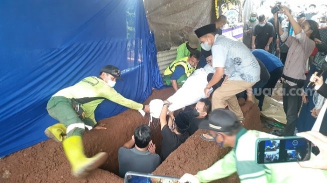 Penampakan jenazah Wimar Witoelar saat dimasukan ke liang lahat di TPU Tanah Kusir, Jaksel. (Suara.com/Yaumal)