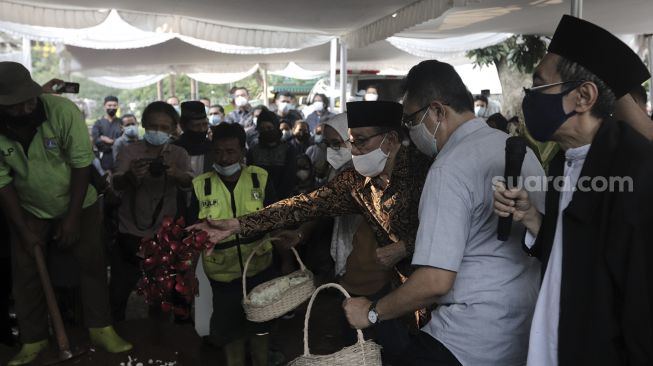 Mantan Ketua DPR-RI Akbar Tanjung (ketiga kanan) menaburkan bunga ke makam mantan Juru Bicara Presiden ke-4 Indonesia Abdurrahman Wahid (Gus Dur), Wimar Witoelar di Tempat Pemakaman Umum (TPU) Tanah Kusir, Jakarta, Rabu (19/5/2021). [Suara.com/Angga Budhiyanto]