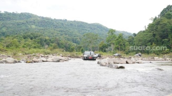 Mobil dinas Plt Gubernur Sulsel Andi Sudirman Sulaiman melintas di Sungai Jeneberang, Kecamatan Manuju, Kabupaten Gowa, Rabu 19 Mei 2021 / [SuaraSulsel.id / Humas Pemprov Sulsel]