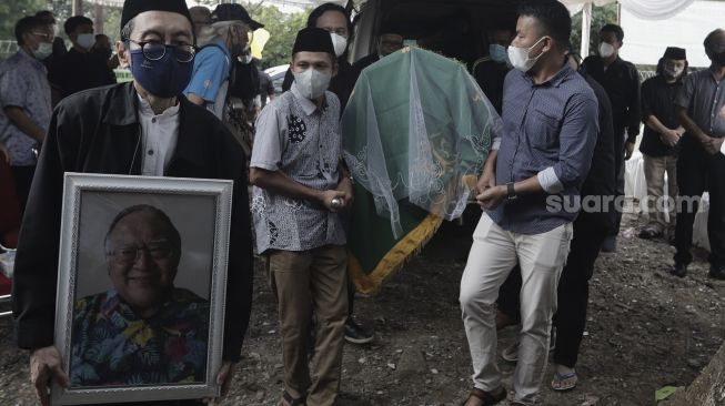 Keluarga dan kerabat mengusung keranda jenazah mantan Juru Bicara Presiden ke-4 Indonesia Abdurrahman Wahid (Gus Dur), Wimar Witoelar di Tempat Pemakaman Umum (TPU) Tanah Kusir, Jakarta, Rabu (19/5/2021). [Suara.com/Angga Budhiyanto]