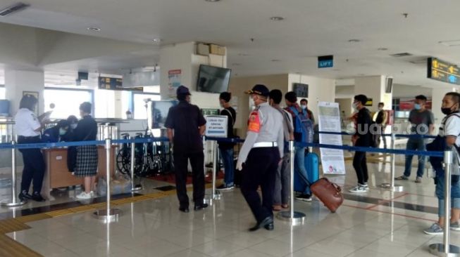 Petugas memeriksa dokumen berupa KTP dan surat keterangan bebas Covid-19 terhadap penumpang yang baru tiba di Terminal Pulo Gebang, Jakarta Timur, Rabu (19/5/2021). [Suara.com/Yosea Arga Pramudita]