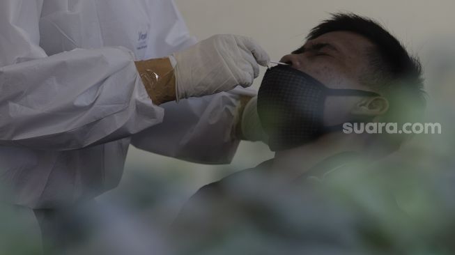 Warga yang telah balik dari mudik menjalani swab test antigen di GOR Kelurahan Kampung Makasar, Jakarta, Kamis (20/5/2021). [Suara.com/Angga Budhiyanto]