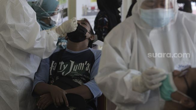 Warga yang telah balik dari mudik menjalani swab test antigen di GOR Kelurahan Kampung Makasar, Jakarta, Kamis (20/5/2021). [Suara.com/Angga Budhiyanto]