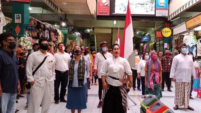 Para pedagang Pasar Beringharjo melakukan sikap sempurna dan menyanyikan lagu Indonesia Raya, Kamis (20/5/2021). [Kontributor / Putu Ayu Palupi]