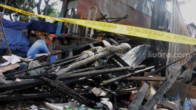 Pedagang membersihkan puing-puing bekas kebakaran di Kawasan Pasar Senen, Jakarta, Kamis (20/5/2021).  [Suara.com/Dian Latifah]