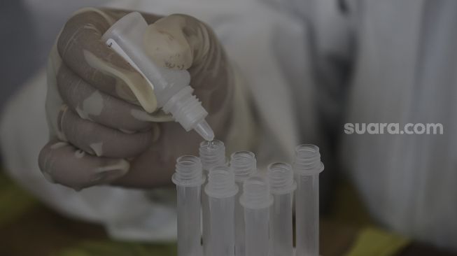 Tenaga Kesehatan melakukan uji sampel hasil swab test antigen milik warga yang telah balik dari mudik di GOR Kelurahan Kampung Makasar, Jakarta, Kamis (20/5/2021). [Suara.com/Angga Budhiyanto]