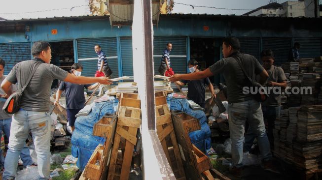 Pedagang membersihkan puing-puing bekas kebakaran di Kawasan Pasar Senen, Jakarta, Kamis (20/5/2021).  [Suara.com/Dian Latifah]