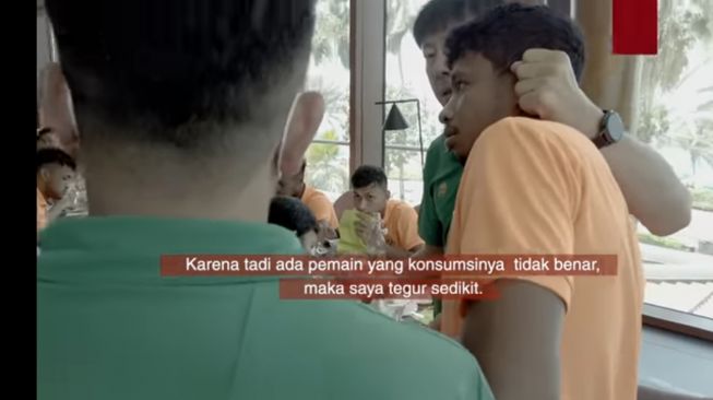 Tangkapan layar tayangan kanal YouTube PSSI, di mana Pelatih Timnas Indonesia Shin Tae-yong jewer Rifad Marassabesy karena makan tidak benar (dok. PSSI).