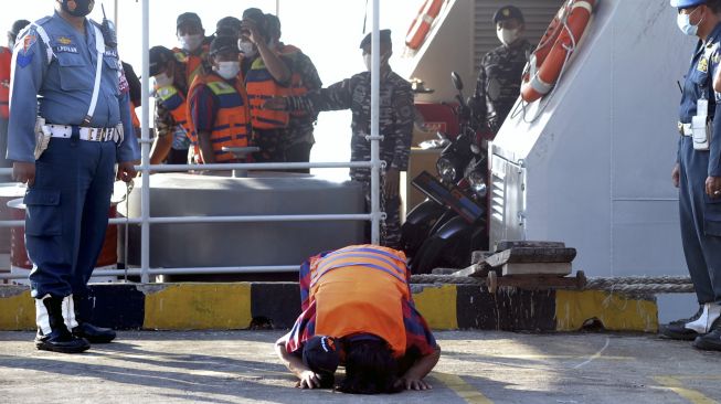 Seorang Anak Buah Kapal (ABK) KM Bandar Nelayan 188 bersujud usai tiba di Pelabuhan Benoa, Denpasar, Bali, Jumat (21/5/2021). [ANTARA FOTO/Fikri Yusuf]