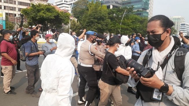 Polisi saat menangkap massa dari HMI saat aksi bela Palestina di Kedubes AS, Jakarta. (Suara.com/Yauma)