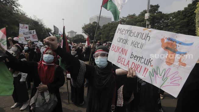 Massa aksi membawa poster saat mengikuti aksi solidaritas dukung Palestina terkait kekerasan yang terjadi beberapa waktu lalu oleh Israel di depan Kedubes AS, Jakarta, Jumat (21/5/2021). [Suara.com/Angga Budhiyanto]