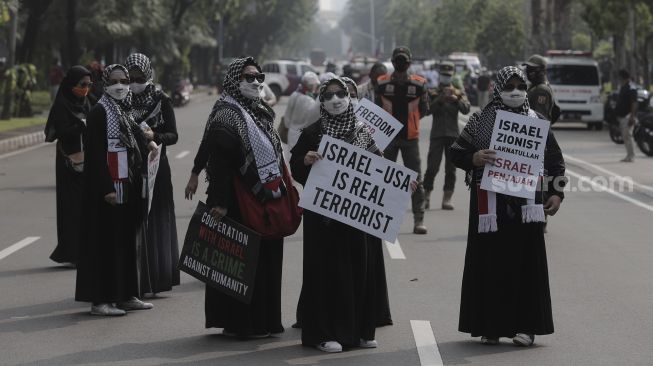 Massa aksi membawa poster saat mengikuti aksi solidaritas dukung Palestina terkait kekerasan yang terjadi beberapa waktu lalu oleh Israel di depan Kedubes AS, Jakarta, Jumat (21/5/2021). [Suara.com/Angga Budhiyanto]