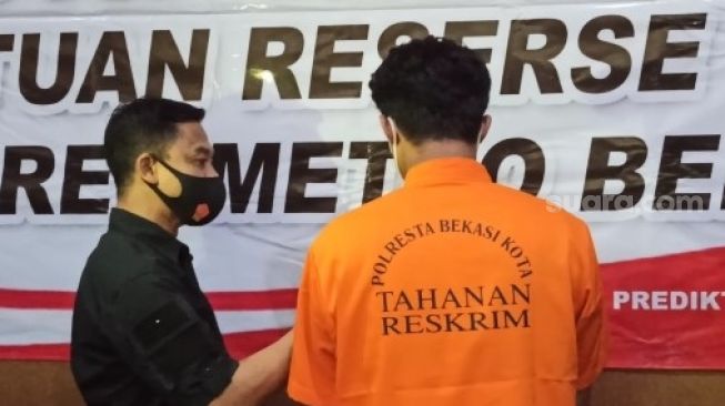 Anak anggota DPRD Bekasi Tersangka Kasus Pemerkosaan AT (21) saat dihadirkan dalam konferensi pers di Aula Polres Metro Bekasi Kota.[Suara.com/Imam Faishal]