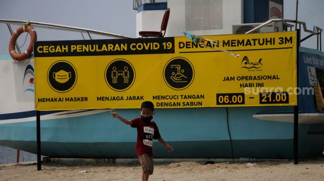 Seorang anak bermain di kawasan Pantai Ancol, Jakarta, Sabtu (22/5/2021). [Suara.com/Dian Latifah]