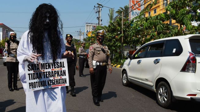 Personel Polres Madiun Kota menggelar sosialisasi imbauan penerapan protokol kesehatan (prokes) COVID-19 di Kota Madiun, Jawa Timur, Sabtu (22/5/2021).  ANTARA FOTO/Siswowidodo