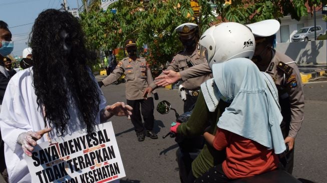 Personel Polres Madiun Kota menggelar sosialisasi imbauan penerapan protokol kesehatan (prokes) COVID-19 di Kota Madiun, Jawa Timur, Sabtu (22/5/2021).  ANTARA FOTO/Siswowidodo