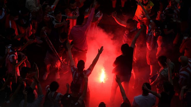 Fans Atletico Madrid turun ke jalan untuk merayakan kesuksesan tim kesayangannya meraih juara La Liga, Madrid, Spanyol, Sabtu (22/5). OSCAR DEL POZO / AFP