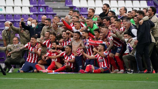 Para pemain Atletico Madrid merayakan keberhasilan mereka menjadi juara La Liga Spanyol setelah menang atas Real Valladolid FC di Jose Zorilla Stadium, Spanyol, Sabtu (22/5). CESAR MANSO / AFP