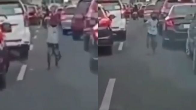 Aksi bocah buka jalan ambulans di tengah kemacetan. (Instagram/makasar_info)