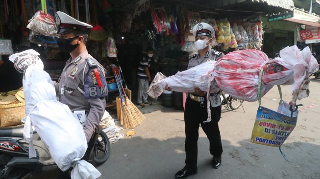 Anggota Satlantas Polres Kediri Kota menggelar sosialisasi penerapan protokol kesehatan (prokes) di Pasar Bandar, Kota Kediri, Jawa Timur, Senin (24/5/2021). ANTARA FOTO/Prasetia Fauzani