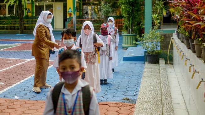 Sejumlah siswa menjaga jarak untuk keluar sekolah saat simulasi pembelajaran tatap muka di SD Cimahi Mandiri 2, Cimahi, Jawa Barat, Senin (24/5/2021). ANTARA FOTO/Raisan Al Farisi