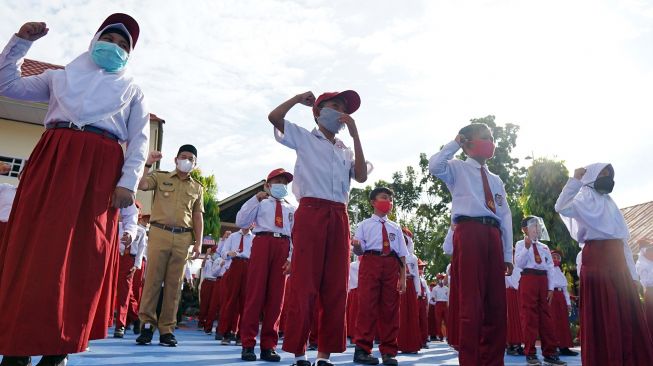 Sejumlah siswa mengikuti upacara pembukaan proses belajar tatap muka di Sekolah Dasar (SD) Negeri 3 Bulango Timur, Kabupaten Bone Bolango, Gorontalo, Senin (24/5/2021).  ANTARA FOTO/Adiwinata Solihin