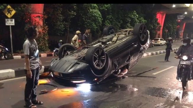 Mobil Mewah Porsche Hitam Terguling di Jalan Antasari