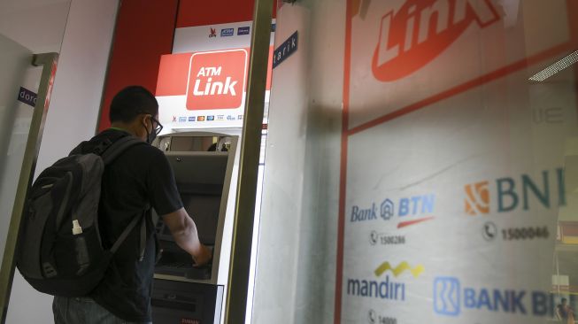 Nasabah melakukan transkasi melalui mesin Anjungan Tunai Mandiri (ATM) Link di Jakarta, Minggu (23/5/2021). ANTARA FOTO/Galih Pradipta