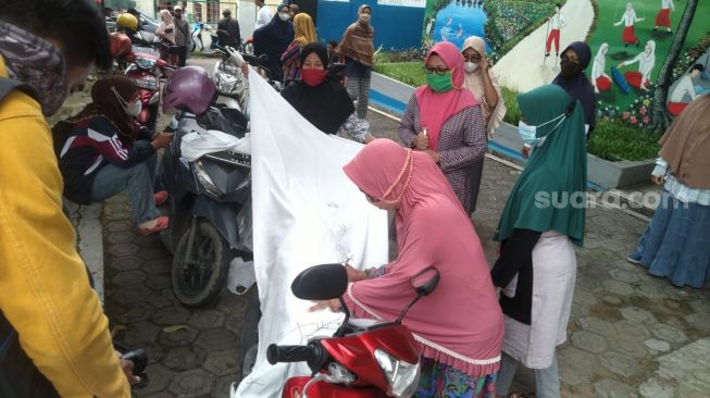 Wali murid tanda tangan penolakan alih fungsi SD Kubang Kutu 2 [SuaraBanten.id/Adi Mulyadi]