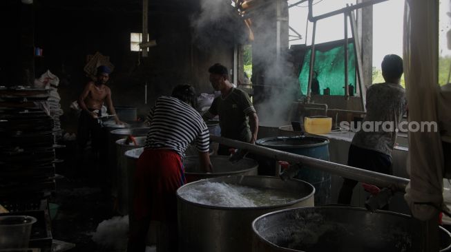 Pekerja menyelesaikan pembuatan tahu di pabrik tahu di jalan Satopati, Bantargebang, Bekasi, Selasa (25/5/2021).  [Suara.com/Dian Latifah]
