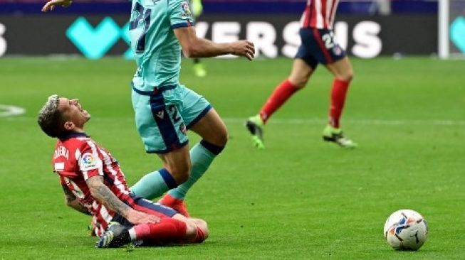 Pemain Atletico Lucas Torreira dijatuhkan pemain Levante dalam pertandingan La Liga yang berlangsung di Estadio Wanda Metropolitano, 20 Februari 2021. [AFP]