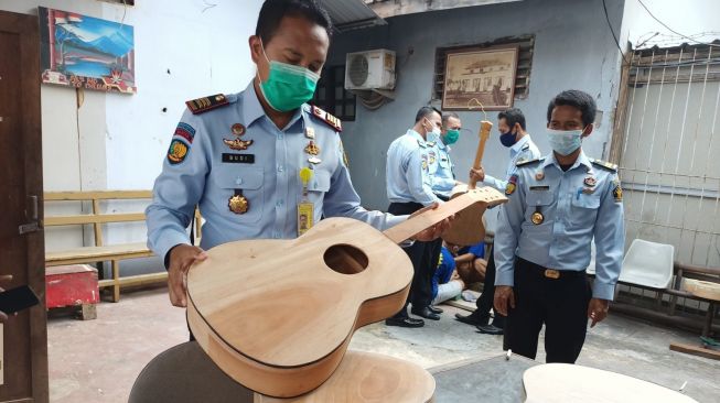 Petugas lapas menunjukan bagian dari gitar yang diproduksi napi Lapas Rangkasbitung [IST]