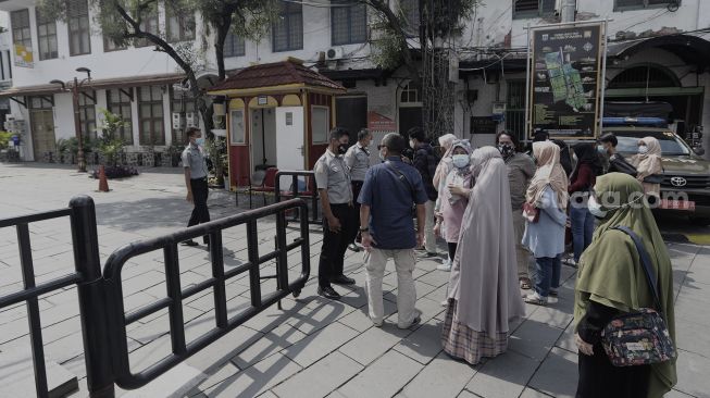 Sejumlah pengunjung mengantre untuk memasuki pelataran Museum Fatahillah di kawasan Wisata Kota Tua, Jakarta, Rabu (26/5/2021). [Suara.com/Angga Budhiyanto]