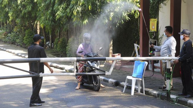 
Warga disemprot disinfektan saat keluar dari Perumahan Griya Melati, Kelurahan Bubulak, Kota Bogor, Jawa Barat, Rabu (26/5/2021). [ANTARA FOTO/Arif Firmansyah]