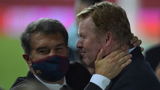 Presiden Barcelona Joan Laporta (kiri) memberi selamat kepada pelatih Ronald Koeman usai timnya mengalahkan Athletic Bilbao di final Copa del Rey yang digelar pada 17 April 2021. [AFP]