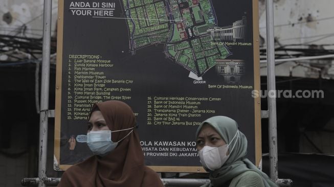 Pengunjung berdiri di depan peta kawasan Wisata Kota Tua, Jakarta, Rabu (26/5/2021). [Suara.com/Angga Budhiyanto]