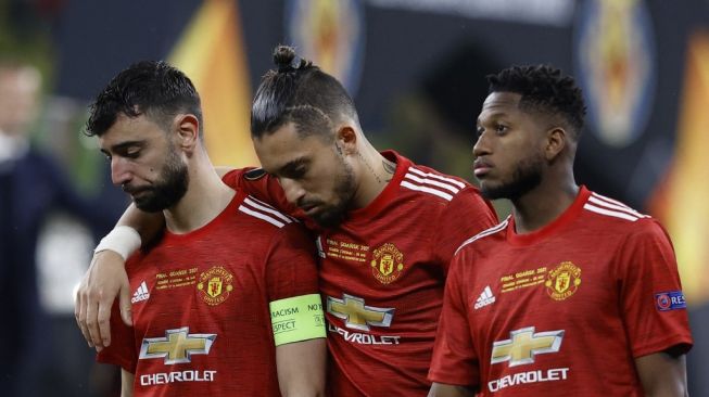 Gelandang Manchester United, Bruno Fernandes (kiri) bersama Alex Telles, dan Fred terlihat kecewa setelah timnya kalah dari Villarreal di babak final Liga Europa 2020/2021, di Stadion Miejski, Gdansk, Polandia, Kamis (27/5/2021) dini hari WIB. [KACPER PEMPEL / POOL / AFP].