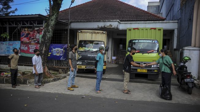 Seorang pegiat sosial Ismaya Safitri memberikan nasi bungkus kepada sejumlah supir truk di Bandung, Jawa Barat, Kamis (27/5/2021). [ANTARA FOTO/Raisan Al Farisi]