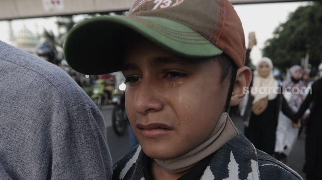 Massa pendukung Habib Rizieq Shihab menagis saat dibubarkan oleh petugas kepolisian usai sidang putusan Habib Rizieq Shihab di Pengadilan Negeri Jakarta Timur, Kamis (27/5/2021). [Suara.com/Angga Budhiyanto]